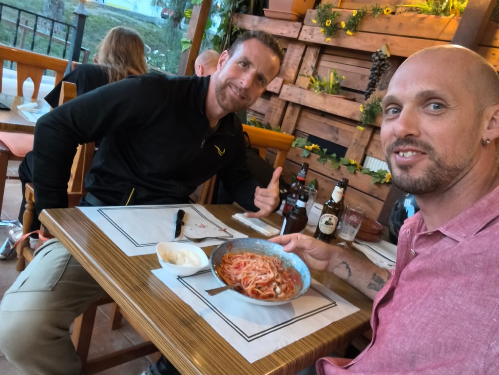 Amigos disfrutando spaghetti al pomodoro en la terraza